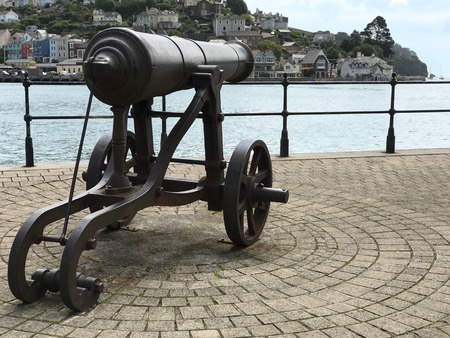 Dartmouth, Devon, UK, JULY 27 2017. An old cannon on the promenade next to the sea and entrance to the harbour.のeditorial素材