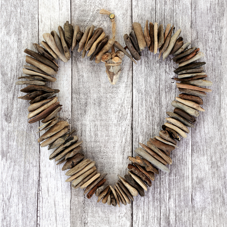 Rustic driftwood heart on wood background.の写真素材