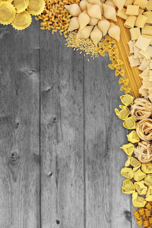 Large collection of Italian pasta varieties on silver grey rustic wood background. Flat lay, top view, copy space.の写真素材