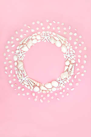 Abstract sea shell wreath with white shell collection. Minimal summer nature composition. Top view, copy space on pink background.の写真素材