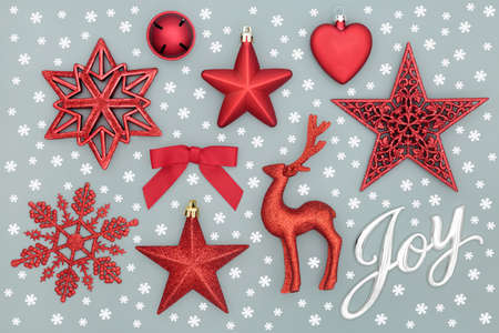 Happy Christmas Joy sign with snowflakes and red baubles on pastel grey background. Festive...