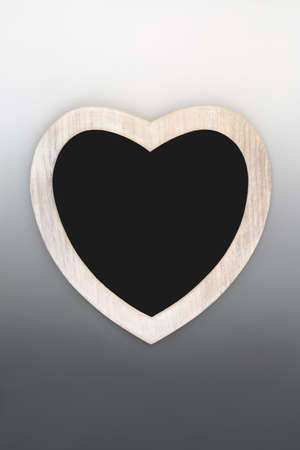 Heart shaped wooden frame with chalkboard on gradient grey background. Symbol of love for Valentines Day, Mothers Day concept, invitation, menu or classroom teaching equipment.の写真素材