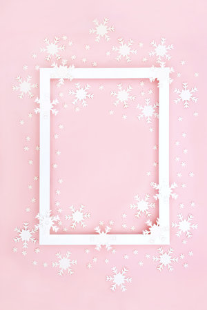 Christmas winter New Year background border on pastel pink with white snowflake decorations. Abstract festive design for greetings card, label, gift tag, menu or invitation.の写真素材