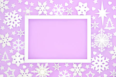 Christmas snowflake festive background frame design on lilac with stars and heart shape decorations. Traditional symbols for winter, Xmas and New Year holiday Season.の写真素材