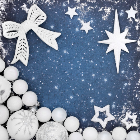 Festive Christmas background with bow and white frosted bauble ornaments on grunge blue background. Magical fantasy abstract concept for winter Xmas and New Year.の写真素材