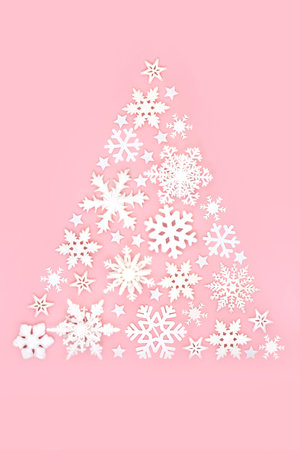 Christmas tree snowflake and star abstract festive design concept on pastel pink background. Magical winter, new year decoration. Stylish composition for the holiday season.の写真素材