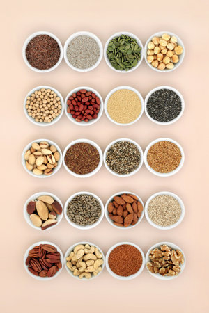 Healthy lipids unsaturated essential fatty acids. Food ingredients containing good fats for a healthy heart and low cholesterol levels with nuts, seeds, legumes and grain. On neutral background.の写真素材