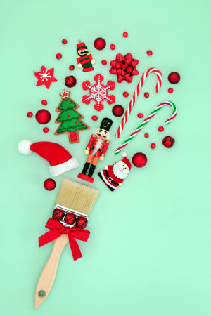 Christmas fun surreal paintbrush splatter concept with tree decorations and red holly berries on pastel green background. Abstract festive design for Xmas and New Year.の写真素材