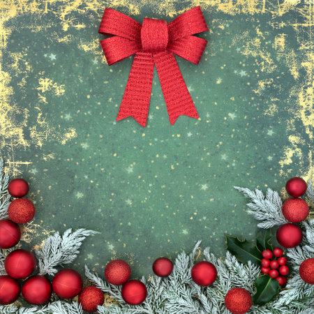 Christmas seasons greetings abstract decorative background with red bow, snow covered fir, holly, tree bauble decorations on grunge green gold. Festive border retro design.の写真素材