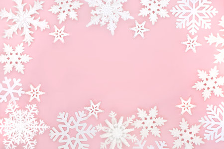 Festive Christmas magical ornate snowflake background on pastel pink. Fantasy design for winter, Xmas, New Year holiday season.の写真素材