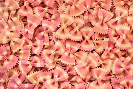 Farfalle bow tie Italian pasta background. Beetroot food dye used for pink colour. Natural healthy...