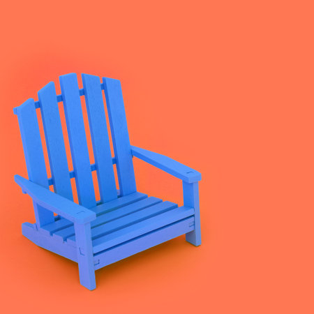 Time for a break with modern blue wooden chair on orange background. Minimal contemporary stylish furniture colour contrast concept. Copy space.の写真素材