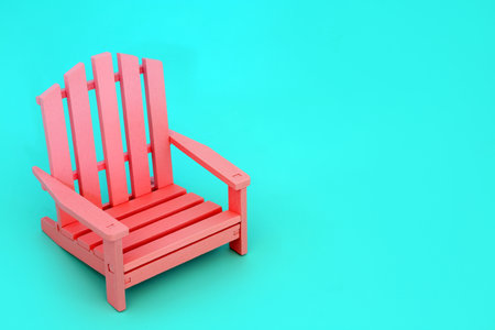 Minimal colour contrast with modern wooden pink chair on pastel blue background. Vivid colours for being different solitary concept. Copy space.の写真素材