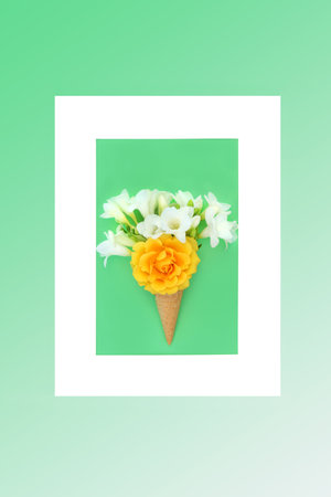 Surreal summer flower ice cream waffle cone bizarre concept with rose and freesia flowers with frame. Abstract minimal nature composition for summertime. On pastel green gradient background.の写真素材