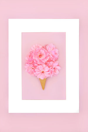 Surreal rose flower bouquet summer ice cream cone concept on pink background with frame. Minimal floral abstract art. For Valentines Day, Mothers Day, bridal, anniversary or birthday design.の写真素材