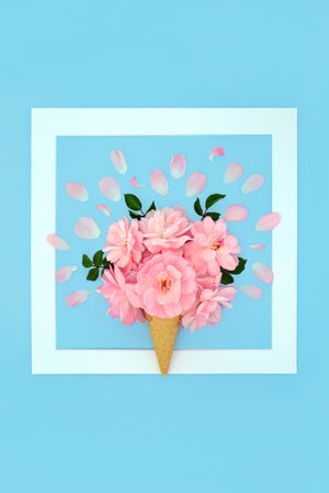 Fantasy surreal summer rose flower ice cream cone concept . Minimal art summer creative fun edible food beautiful floral nature composition on pastel blue background with white frame.の写真素材