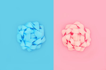Pink for a girl blue for a boy design concept background with two pastel colored rosette bows. Minimal contrast composition of twins, duality and opposites attract.の写真素材