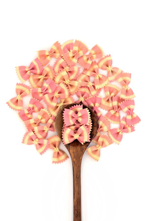 Abstract farfalle Italian bow tie pasta tree shape concept on white background with olive wood...