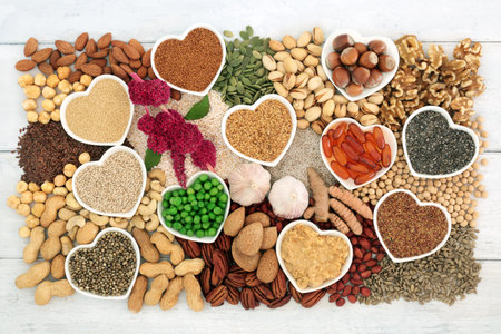 Vegan healthy heart food high in lipids essential fatty acids containing unsaturated good fats for low cholesterol levels with nuts, seeds, vitamin e capsules, vegetables and grain.の写真素材