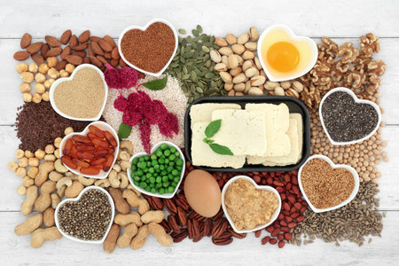 Vegetarian healthy heart food high in lipids essenital fatty acids containing unsaturated good fats for low cholesterol levels with nuts, seeds, dairy, vitamin e capsules, vegetables and grain.の写真素材