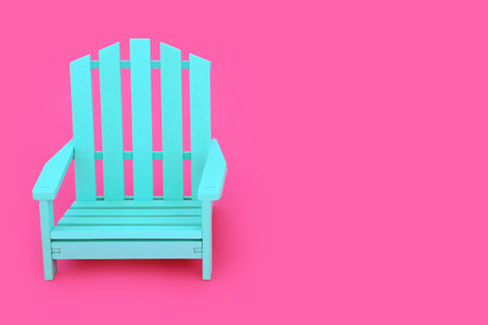 Alone time concept with modern blue wooden chair on vivid pink background. Minimal furniture, solitary, solitude, peaceful, contrast concept. Copy space.の写真素材