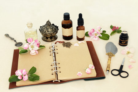 Apple blossom flowers for natural  remedies and herbal flower essence. with notebook, essential oil bottles and quill pen.  Stress and anxiety relieving, good for digestive health. On hemp paper.の写真素材