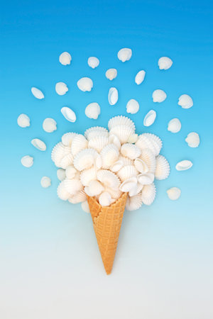 Surreal summer seashell ice cream cone design on gradient blue white background with cockle and cowrie shells. Nature food fun surrealistic art composition.の写真素材