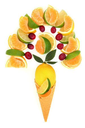 Summer surreal citrus and berry fruit ice cream cone on white background. Healthy fresh food concept with fruits high in antioxidants and vitamin c for immune system boost.の写真素材