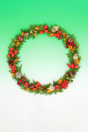 Harvest Festival Autumn Fall Thanksgiving nature wreath with leaves, flowers, berry fruit, nuts and seed heads on gradient green background. Floral design for card, invitation, logo, label.の写真素材