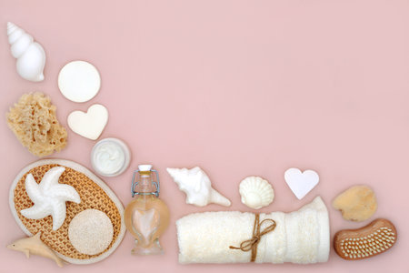 Natural skincare bath accessories for beauty treatment on pink background with assorted body care products for radiant skin and decorative seashell soaps.の写真素材
