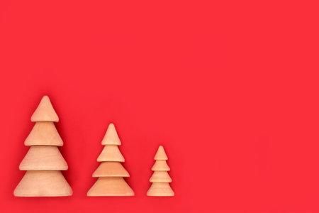Christmas tree wooden ornaments on red background. Eco friendly decoration  for Merry Christmas Noel Yule greeting card, gift tag, letter, menu, invitation.の写真素材