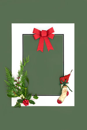 Christmas Eve stocking winter flora and red bow background with white frame on green. Abstract retro design for greeting card, label, invitation, menu, gift tag.の写真素材