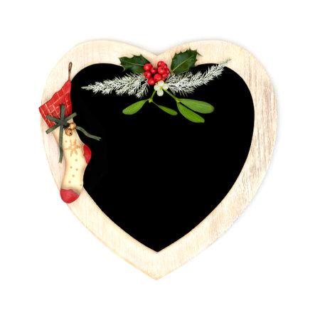 Christmas  heart shape wreath with retro metal stocking, winter holly, mistletoe, fir. Traditional romantic symbol for the holiday season. Chalkboard on white background.の写真素材