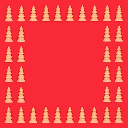 Christmas tree wooden ornaments on red background with copy space. Eco friendly decoration for Merry Christmas Noel Yule greeting card, gift tag,  menu, invitation.の写真素材