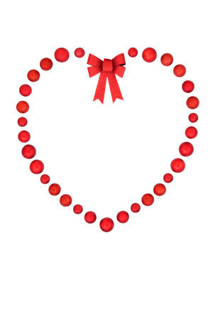 Christmas heart shape wreath with red bauble ball and bow decorations. Minimal romantic symbol on white background. Greeting card, menu, invitation, gift tag and label.の写真素材