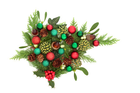 Christmas winter flora greenery with red and green ball decorations on white background. Traditional festive nature  display for the holiday season, Yule, Noel, New Year.の写真素材