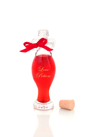 Love potion bottle with red liquid magical concoction on white background. Valentines Day lovers relationship romantic abstract concept.の写真素材