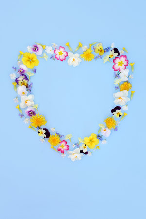Heart shape floral wreath on blue background. Spring flower garland for logo, menu, invitation, card for Valentines, Mothers Day, anniversary, birthday, wedding day.の写真素材