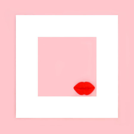 Luscious red lips on pink background with white frame. Abstract surreal minimal Valentines day, birthday, anniversary design.の写真素材