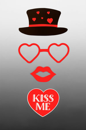 Kiss me romantic Valentines Day abstract with red heart and text with luscious lips, glasses and black hat. Surreal valentine romance design concept on gradient gray white.の写真素材
