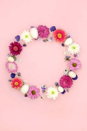 Easter wreath with flowers and eggs on pink background. Decorative floral garland for traditional seasonal nature design.の写真素材