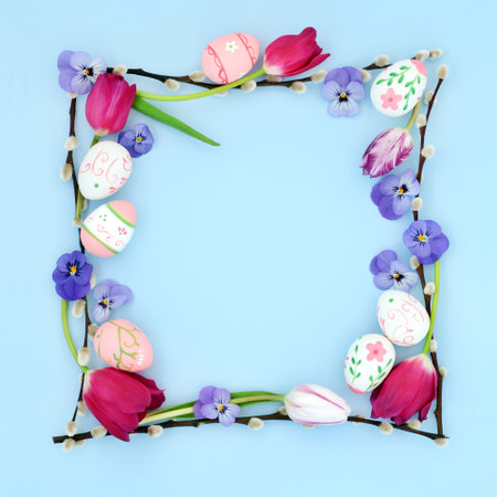 Abstract Easter background border with decorative eggs, flowers and willow branches on pastel blue. Minimal natural fun nature frame for the holiday season.の写真素材