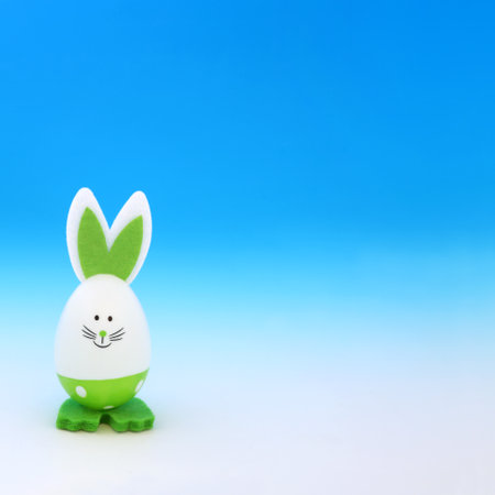 Easter bunny green egg on gradient blue white background. Minimal cute composition for the festive holiday season with go green environmentally friendly theme.の写真素材