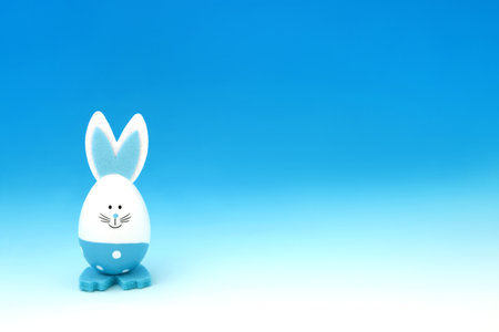 Easter bunny blue egg on gradient background. Minimal cute fun composition with for the holiday season with solitary theme.の写真素材