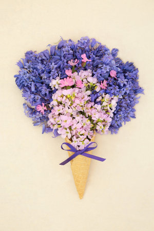 Surreal spring bluebell, red campion and cuckoo flower ice cream cone on hemp paper background. Floral fun wildflower nature composition of springtime British flowers.の写真素材