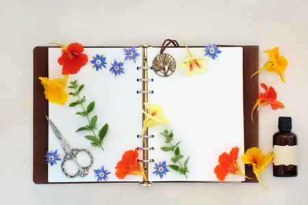 Natural alternative herbal medicine for colds and flu remedy with borage, nasturtium and lemon balm herbs and flowers with old leather notebook. On hemp paper background.の写真素材