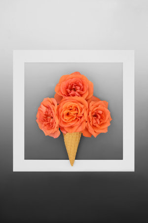 Abstract summer ice cream cone with orange rose flowers on gradient gray background with white...