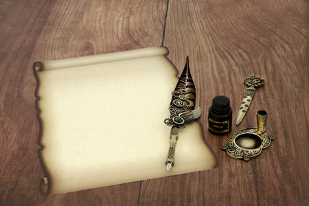 Parchment faded paper scroll with old feather quill pen, ink, letter opener. Retro writing equipment for vintage manuscript, diploma, document, letter on rustic wood.の写真素材