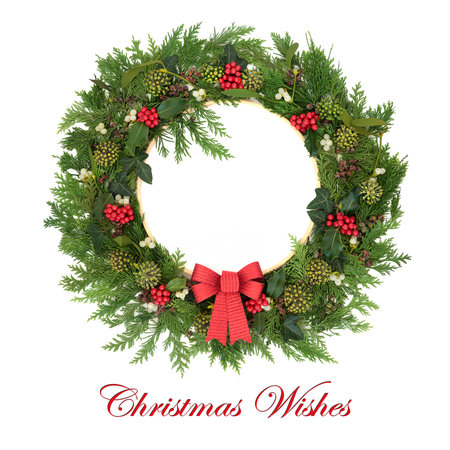 Christmas wishes winter wreath with holly, mistletoe berries, ivy, cedar, red bow on white with frame. Natural traditional nature design for Yule Noel Xmas. With text.の写真素材