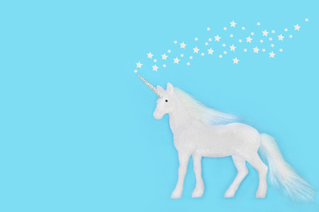 Fantasy unicorn Christmas decoration with white stars background on blue. Magical festive tree bauble  Greeting card, gift tag invitation. Copy space.の写真素材